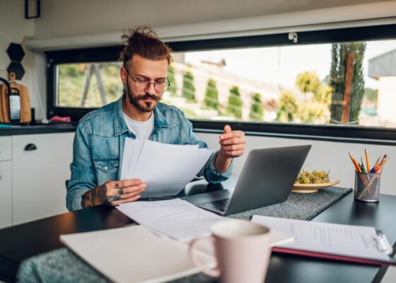 A CFO working from home learning about how AI will change his role as CFO. Work from home set up is in a kitchen.