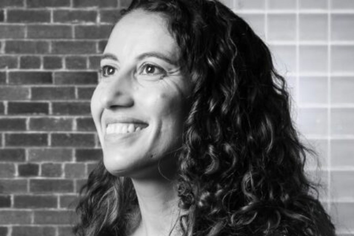 Temple Bright's Melania Badain is pictured smiling outside. The photo is in black and white.